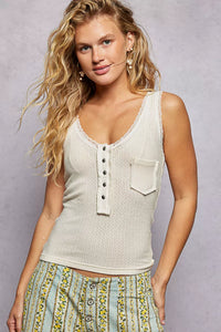 Woman wearing a sleeveless top with a pocket against a plain background