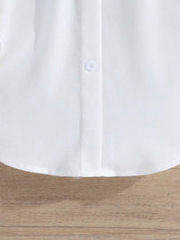 Close-up of a white shirt collar on a wooden surface