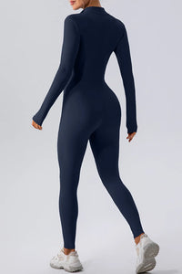 Person wearing a navy blue jumpsuit on a light gray background