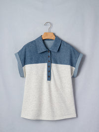 Two-tone blue and white shirt on a hanger against a gray background