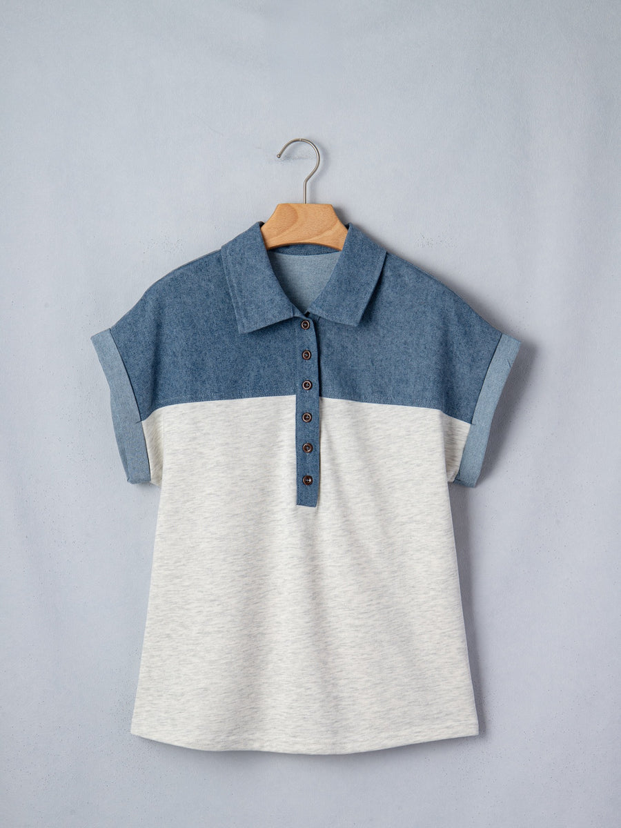Two-tone blue and white shirt on a hanger against a gray background