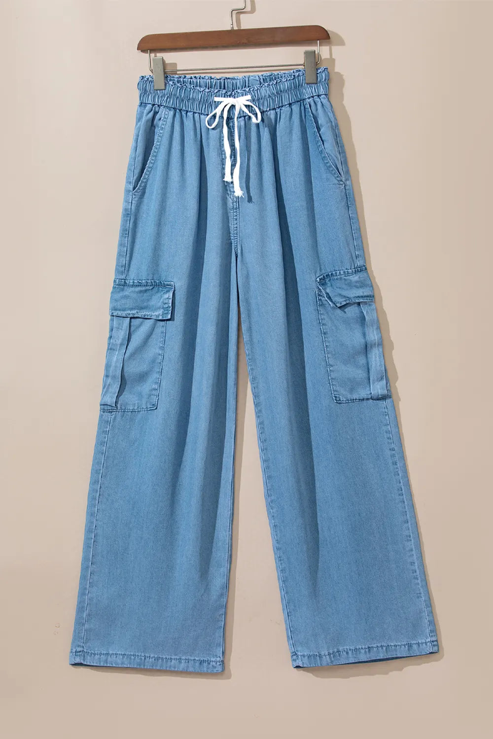 Blue denim cargo pants on a beige background