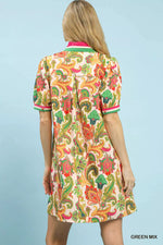 Woman wearing a colorful patterned dress against a light blue background
