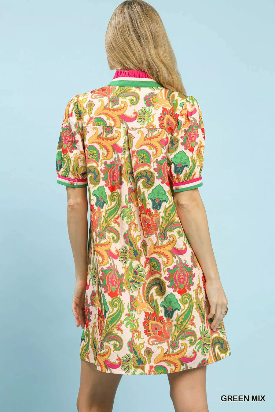 Woman wearing a colorful patterned dress against a light blue background