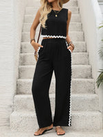 Woman in a black outfit with white trim standing on a staircase.