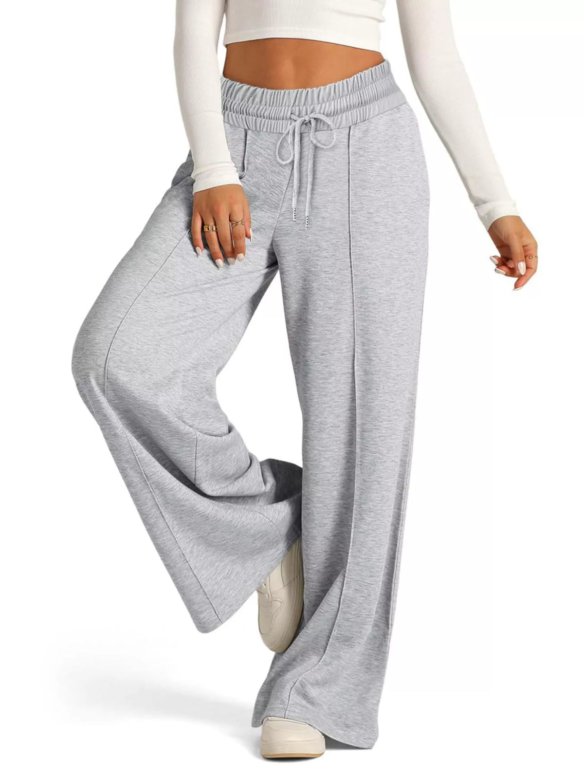 Gray sweatpants worn by a person on a white background