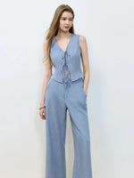 Woman wearing a light blue jumpsuit on a white background