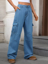Person wearing blue cargo pants standing on a stone pavement.