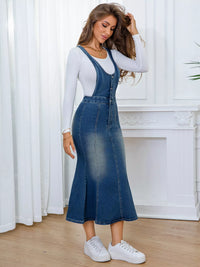Woman wearing a denim dress over a white long-sleeve shirt with white sneakers, standing in a room with white curtains and a white fireplace.