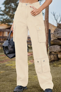 Person wearing beige cargo pants holding a black bag outdoors.