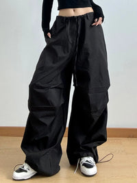Person wearing black wide-leg pants with a plain background