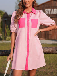 Woman wearing a pink and white striped dress with pink accents outdoors.