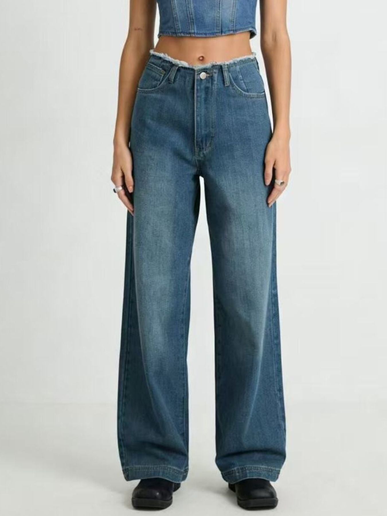 Person wearing blue jeans on a plain background