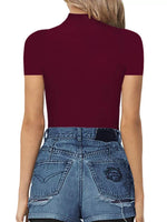 Person wearing a maroon short-sleeve top and blue jeans on a white background