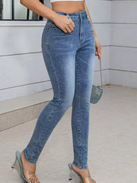 Person wearing high-waisted blue jeans with a blurred background