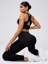 Woman wearing a black athletic outfit with cut-out design on a white background