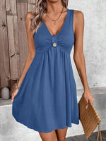 Woman wearing a blue dress with a wooden wall and gray floor background