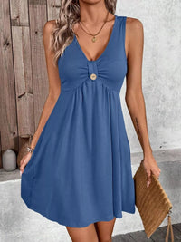 Woman wearing a blue dress with a wooden wall and gray floor background