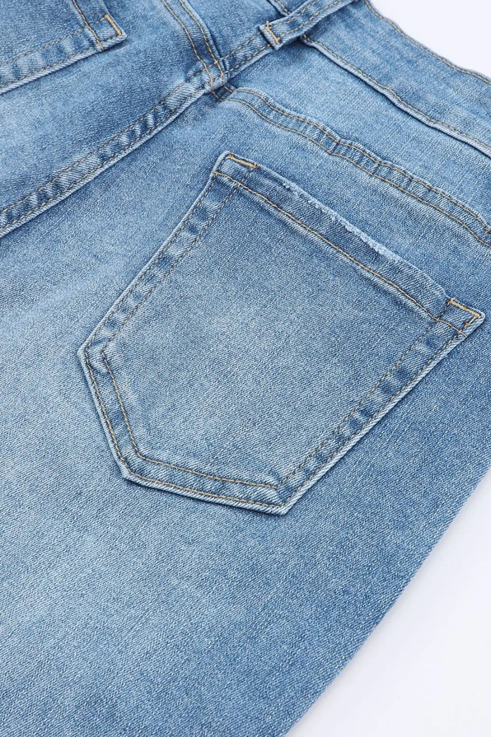 Close-up of a blue denim pocket on a white background