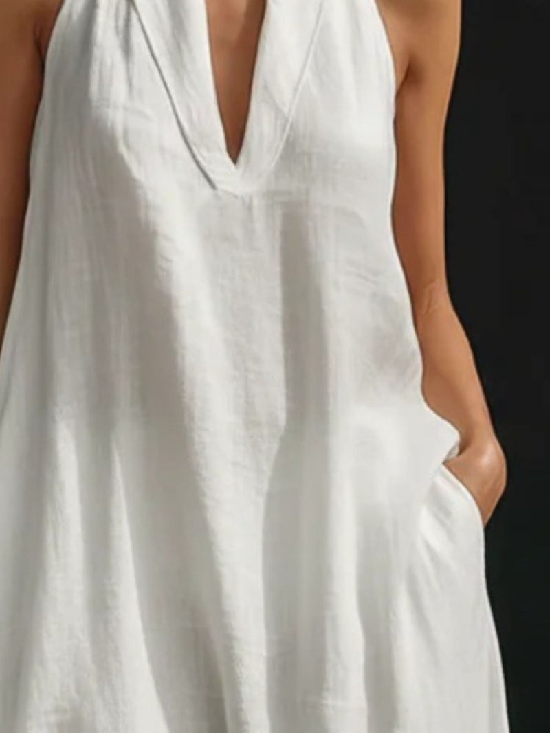 White sleeveless dress worn by a person on a black background
