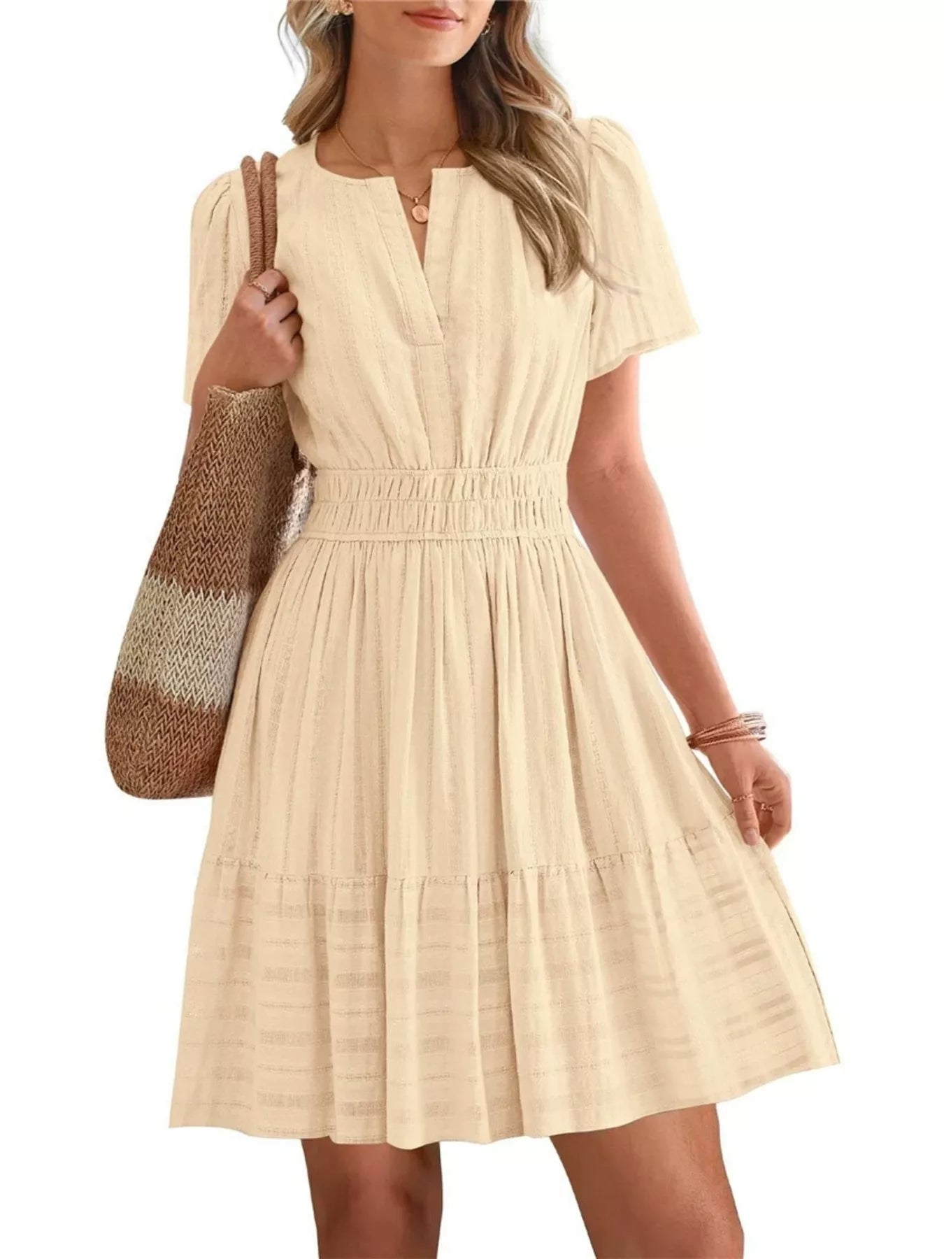 Beige dress worn by a person on a white background