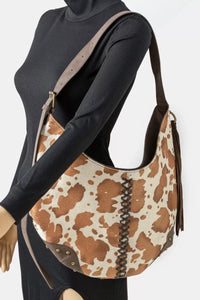 Mannequin wearing a black outfit with a brown and beige patterned handbag.