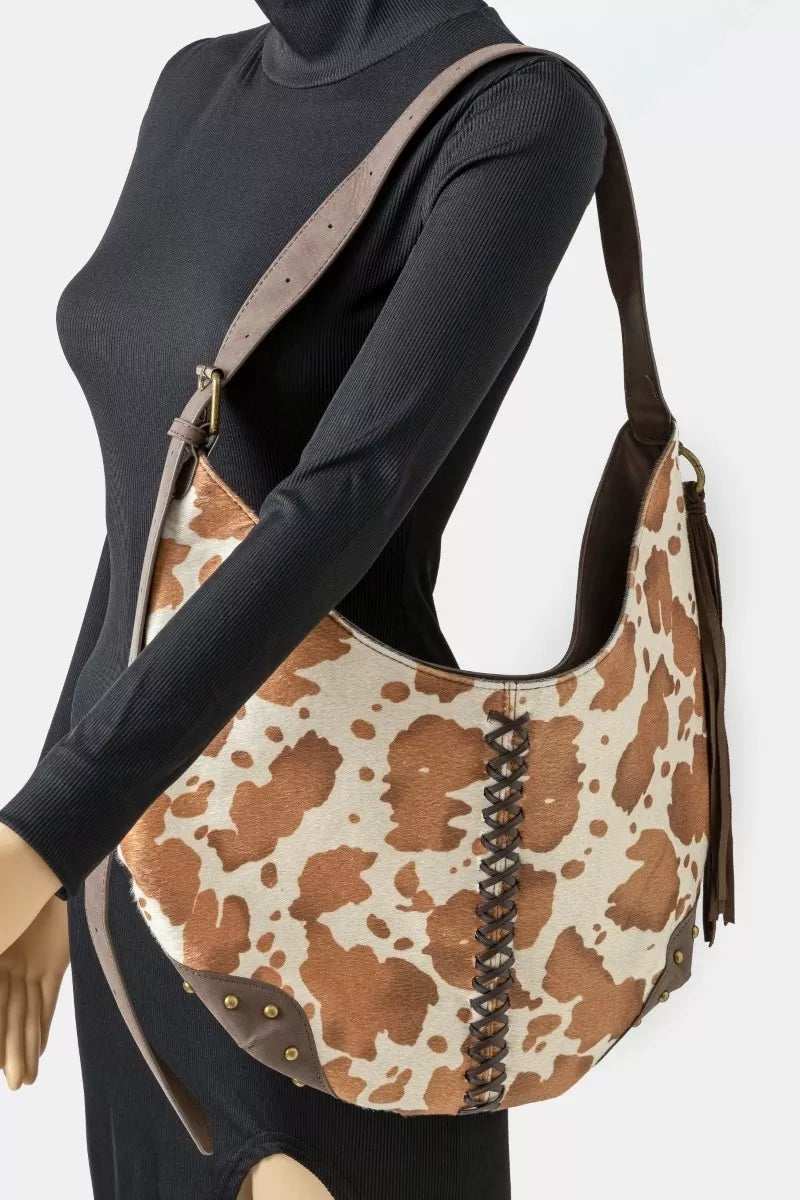 Mannequin wearing a black outfit with a brown and beige patterned handbag.