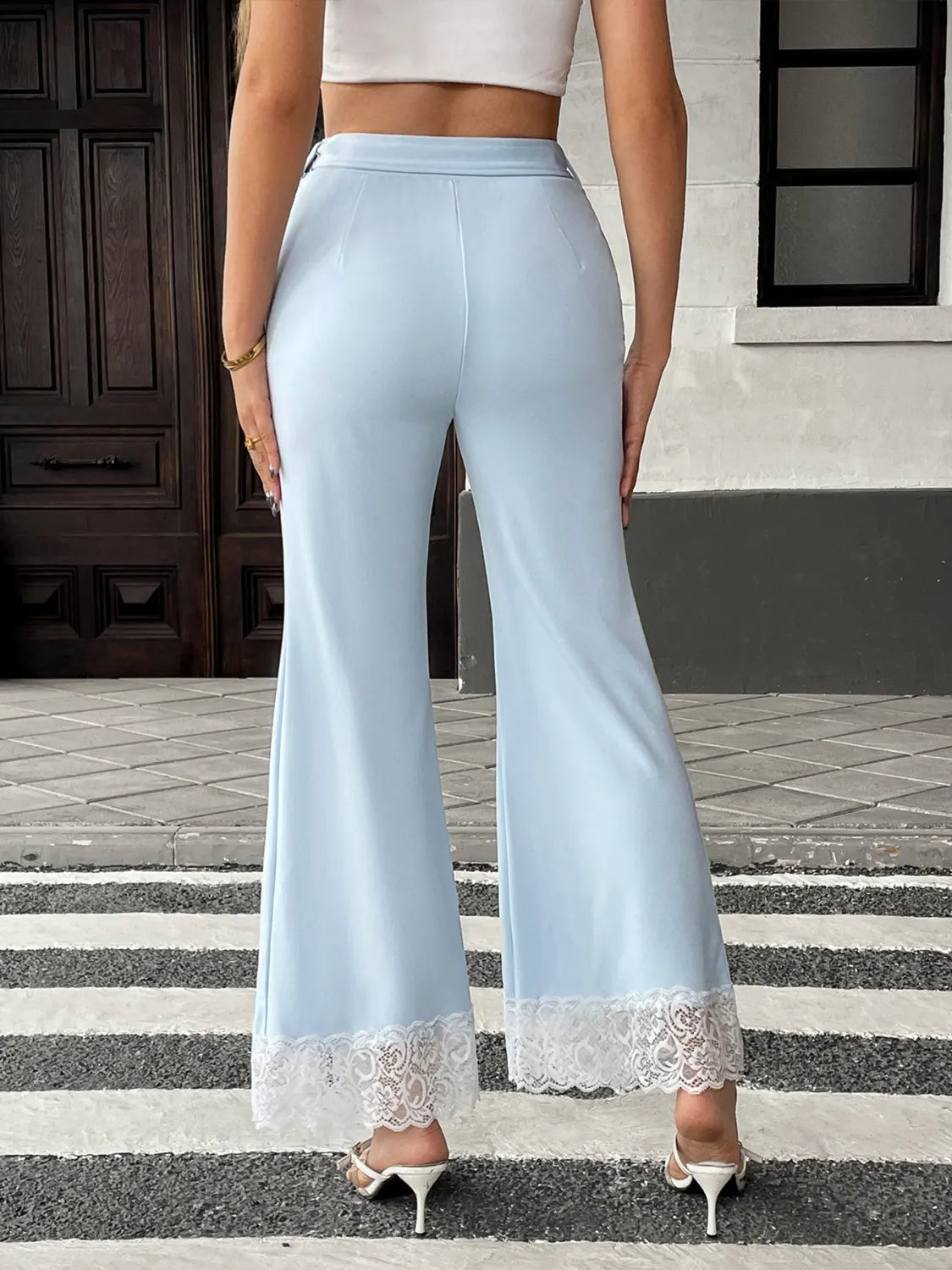 Light blue pants with lace trim worn by a person on a street.