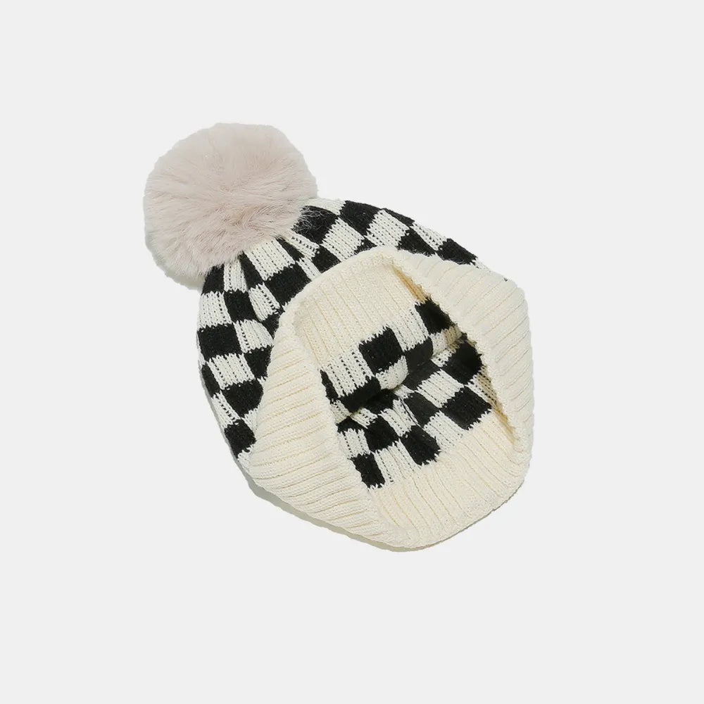 Knitted beanie with checkered pattern and pom-pom on a white background