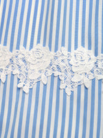 Close-up of blue and white striped fabric with lace trim