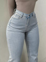 Light blue jeans worn by a person against a plain background