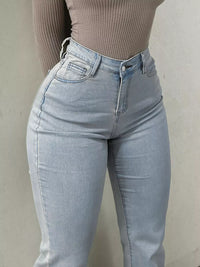 Light blue jeans worn by a person against a plain background