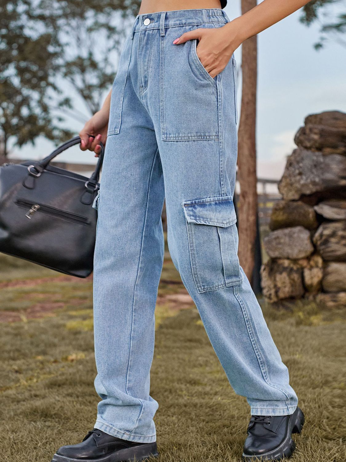 Person wearing light blue jeans outdoors with a blurred background