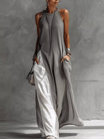 Woman wearing a long gray dress against a neutral background