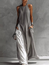 Woman wearing a long gray dress against a neutral background