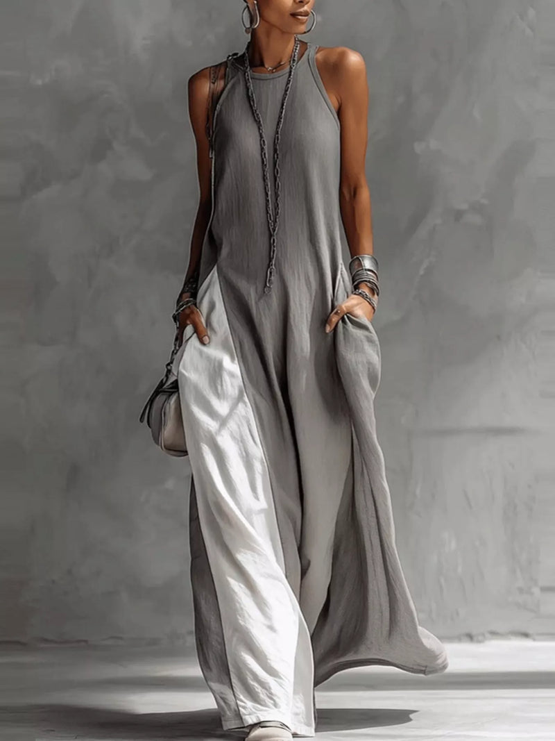 Woman wearing a long gray dress against a neutral background