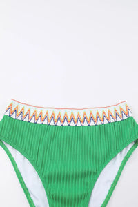 Green bikini bottom with colorful waistband on a white background