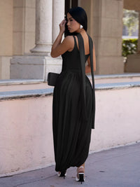 Woman in a black dress standing in front of classical architecture