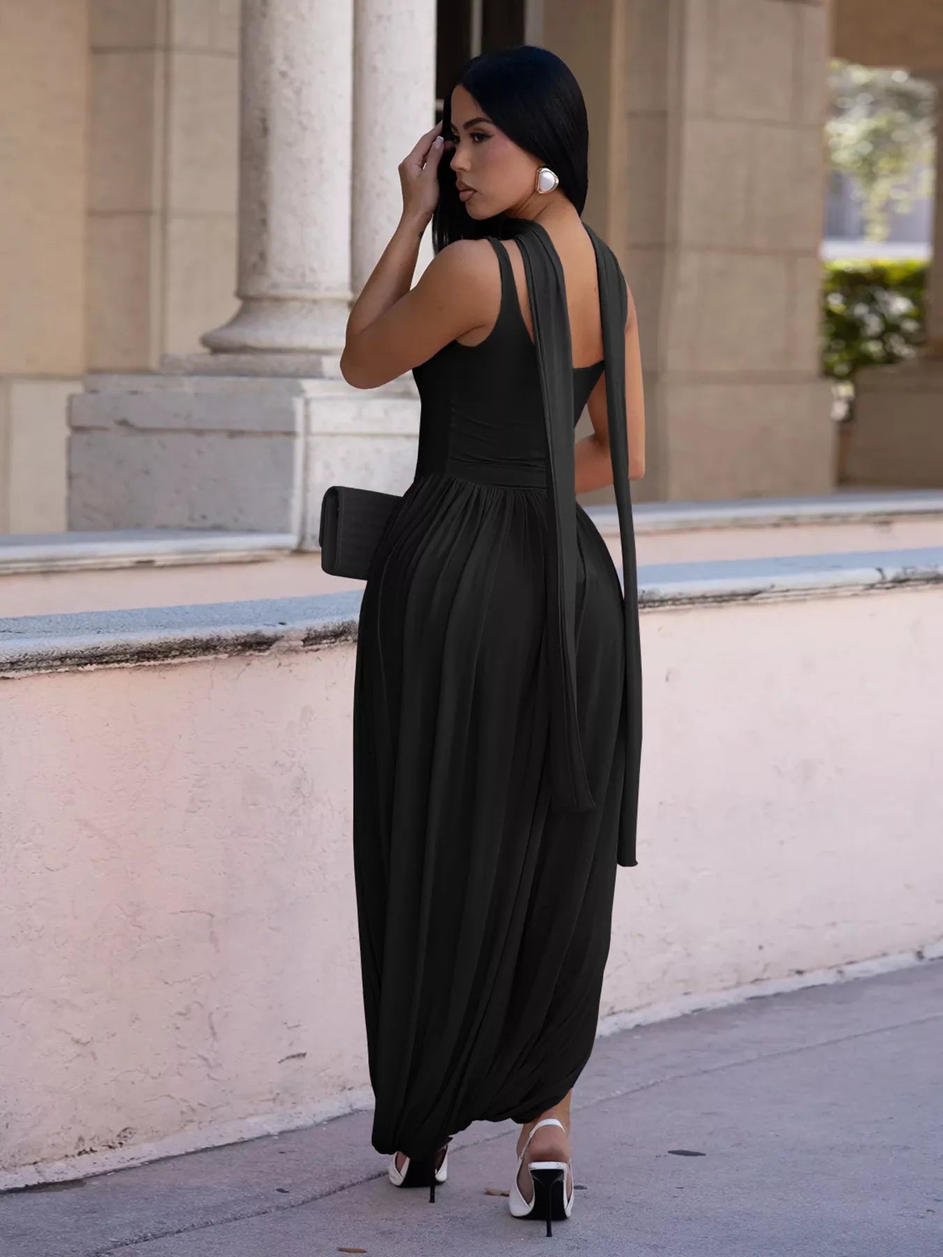 Woman in a black dress standing in front of classical architecture