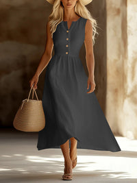 Woman in a long dark dress holding a woven bag in a warm-toned setting