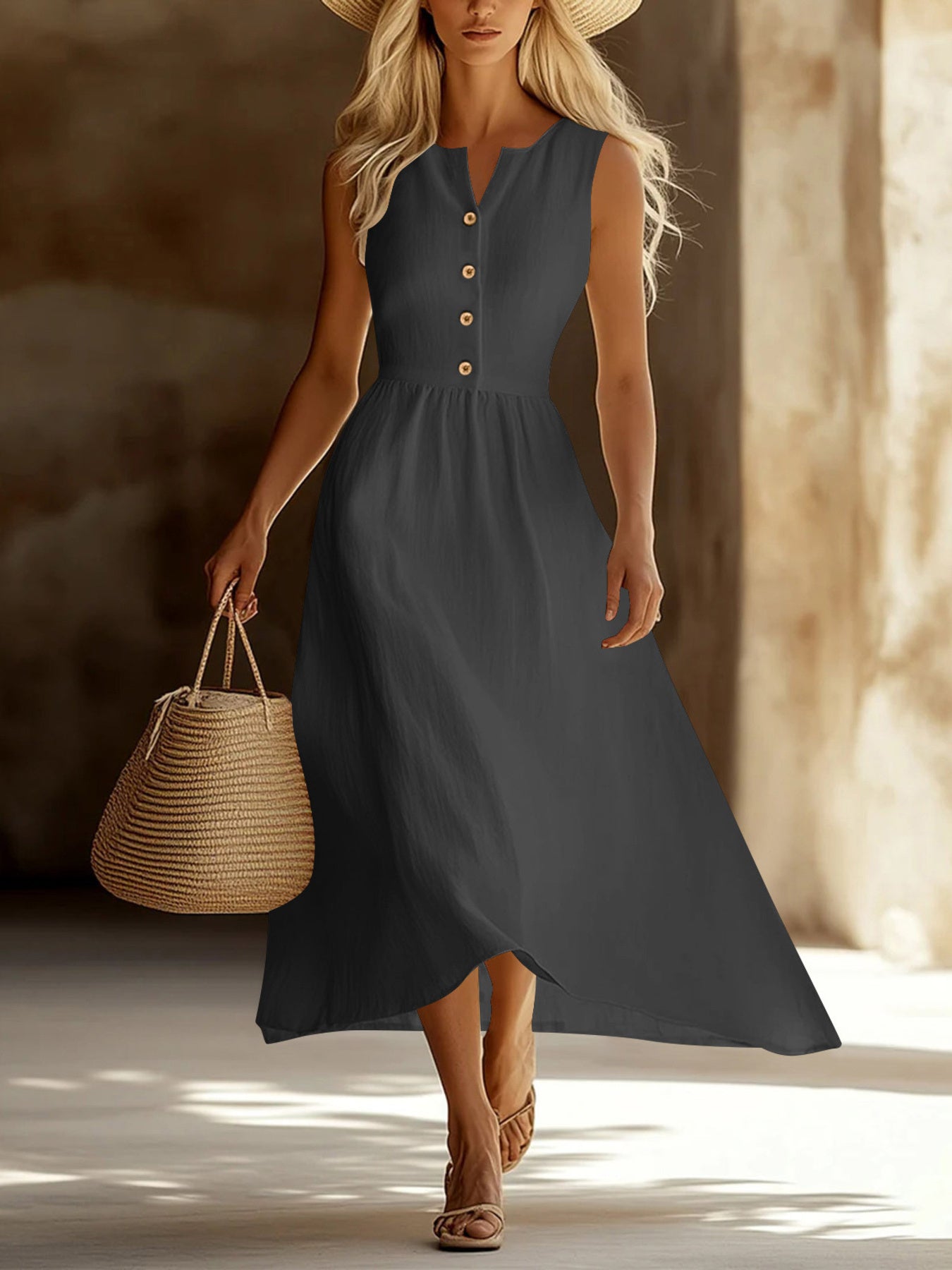 Woman in a long dark dress holding a woven bag in a warm-toned setting