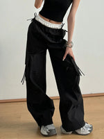 Person wearing black cargo pants with a plain background