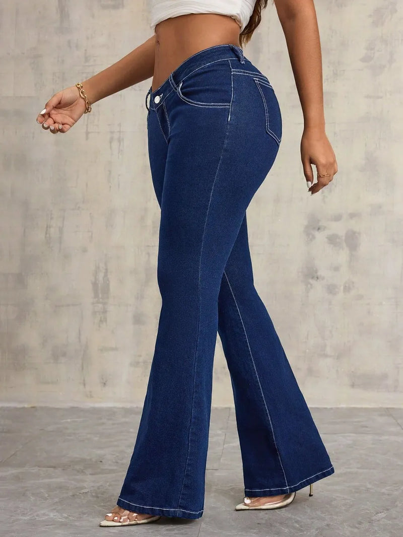 Person wearing blue flared jeans against a neutral background