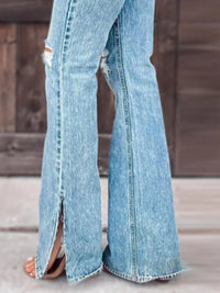 Light blue jeans with a high slit on a wooden floor.