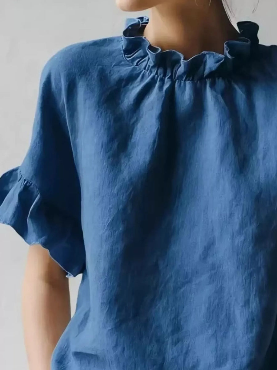 Blue blouse with ruffled neckline on a plain background