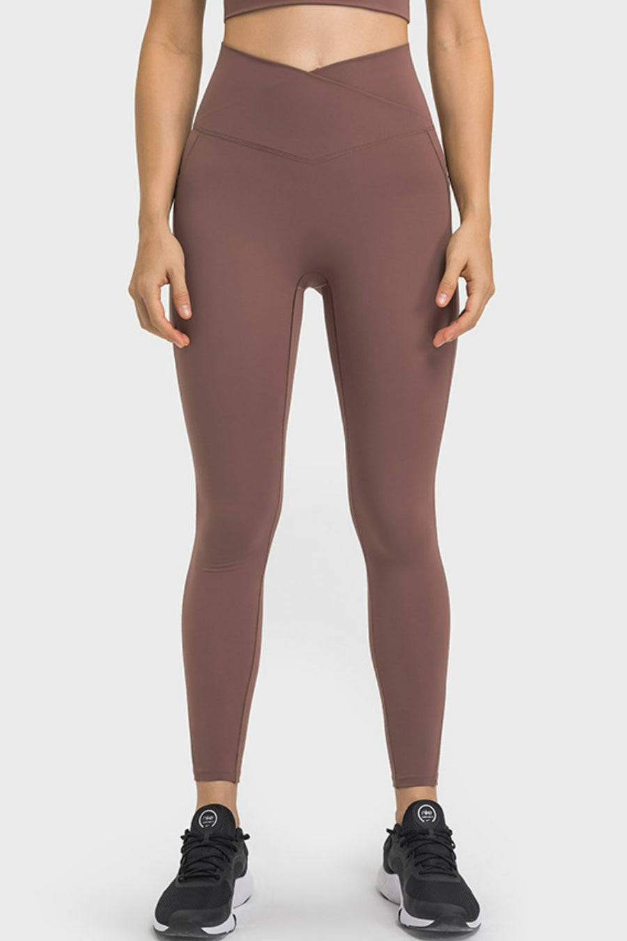 Person wearing brown leggings on a white background