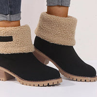 Black ankle boots with beige shearling cuffs on a white background