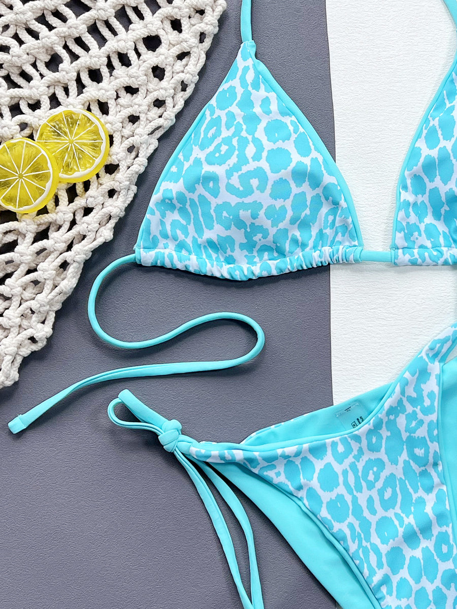 Blue and white patterned bikini set on a textured surface with lemons.