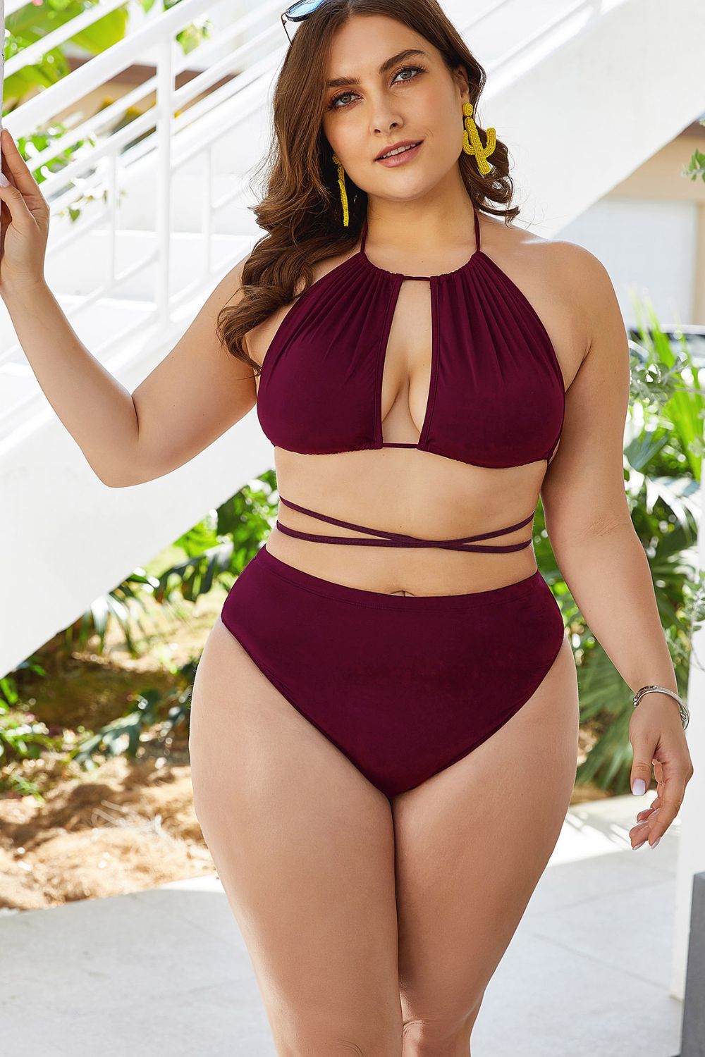 Woman wearing a burgundy bikini set with a white background