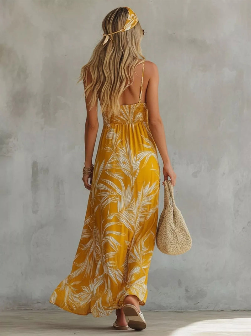 Woman wearing a yellow floral dress against a gray wall